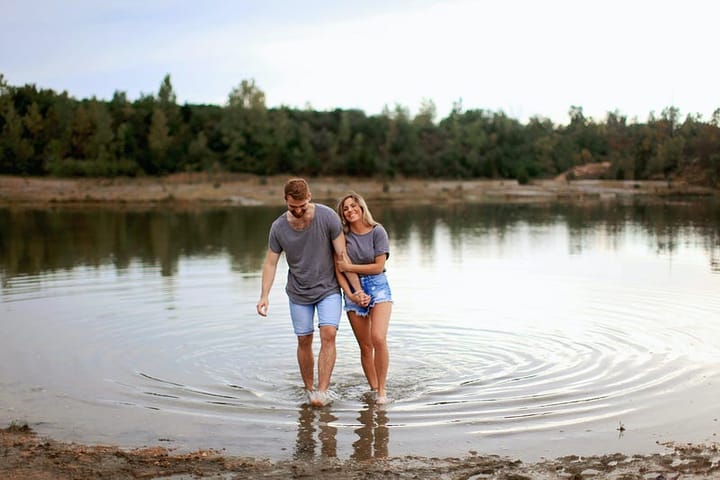 A happy couple standing ankle deep in water