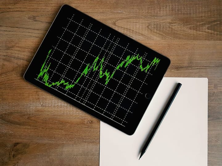 A paper, a pen and a tab with a climbing chart.