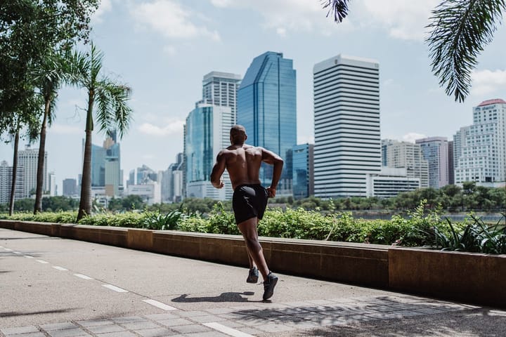 Muscular man jogging in the suburbs