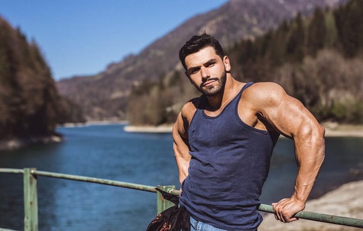 Muscular vested man standing in front of a lake