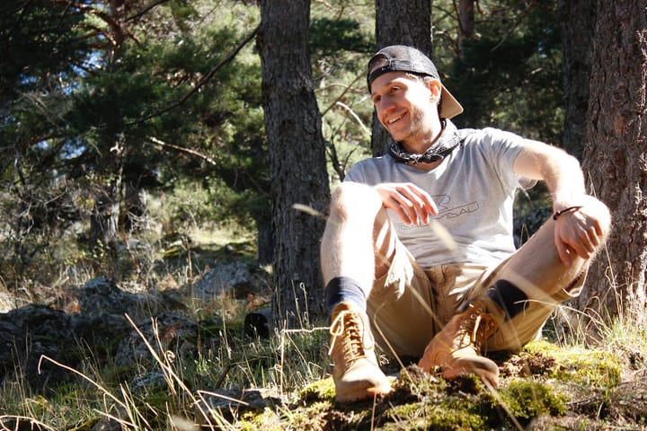 Happy man with a reverse facing cap sitting outdoors