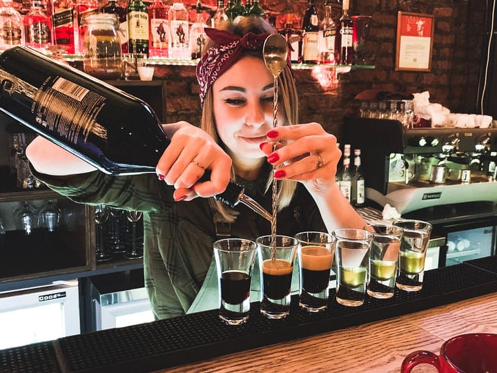 A bartender with a headband pouring out drinks