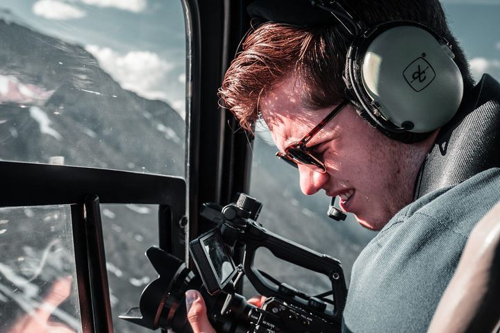 Man presumably in a helicopter recording footage