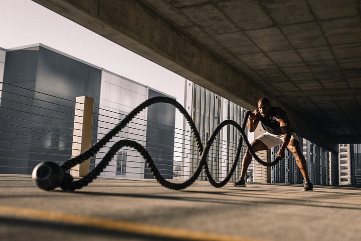 Muscular black man using the battle ropes