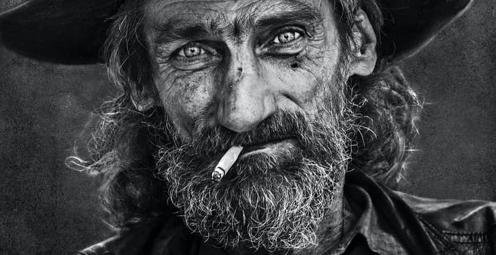 Stunning black and white image of an aged man with a beard and burning cigarette