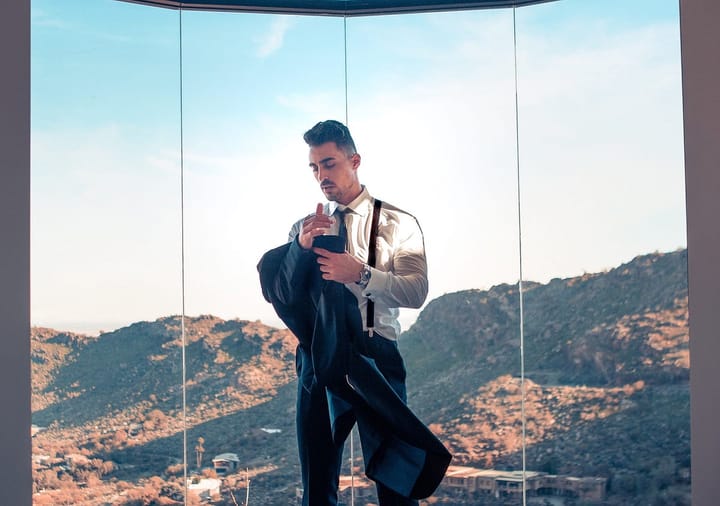Handsome well-dressed formal man in the background of a window overlooking hills