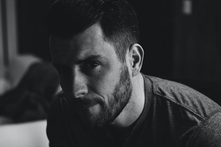Black and white profile photo of a handsome bearded man