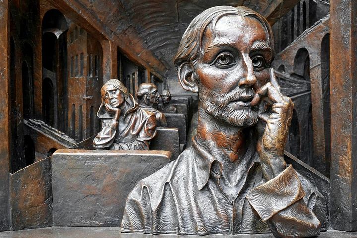 Antique bronze sculptures of a a bunch of people sitting in thought