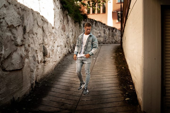 Stylish man walking down a narrow isolated road