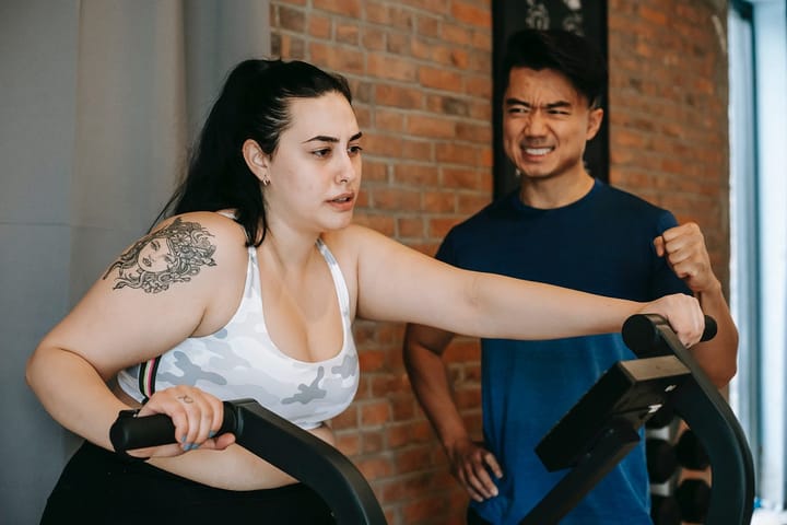 Overweight woman with a shoulder tattoo exercising