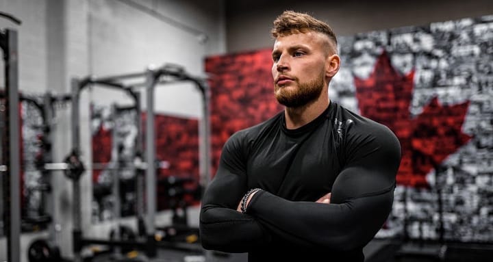Young muscular man in a full-sleeved black shirt crossing his arms