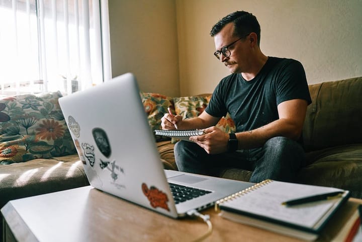 Mustached and spectacled man writing